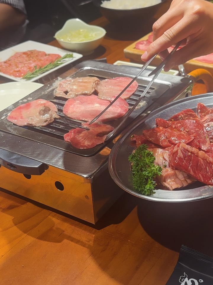 테이블 그릴에 와규를 굽는 손님 — 야키니쿠의 순간