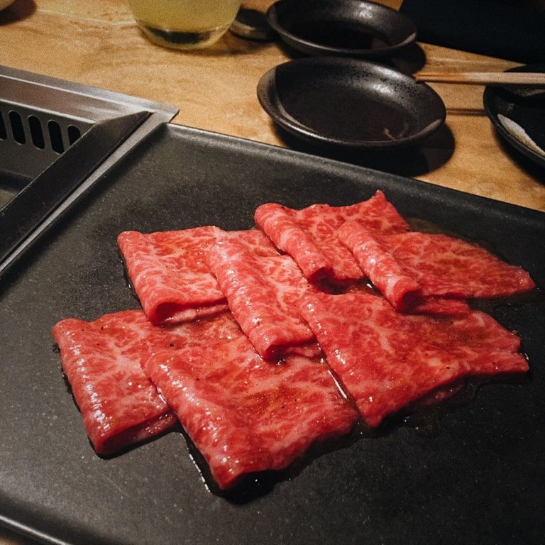 Marbled wagyu slices on a black plate — the summit of the omakase menu