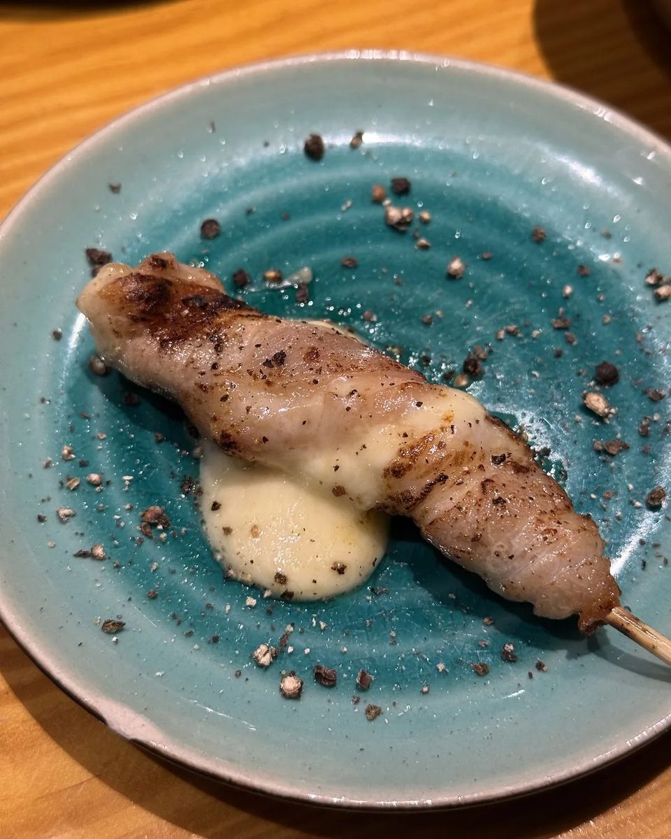 Grilled wrapped skewer on turquoise ceramic
