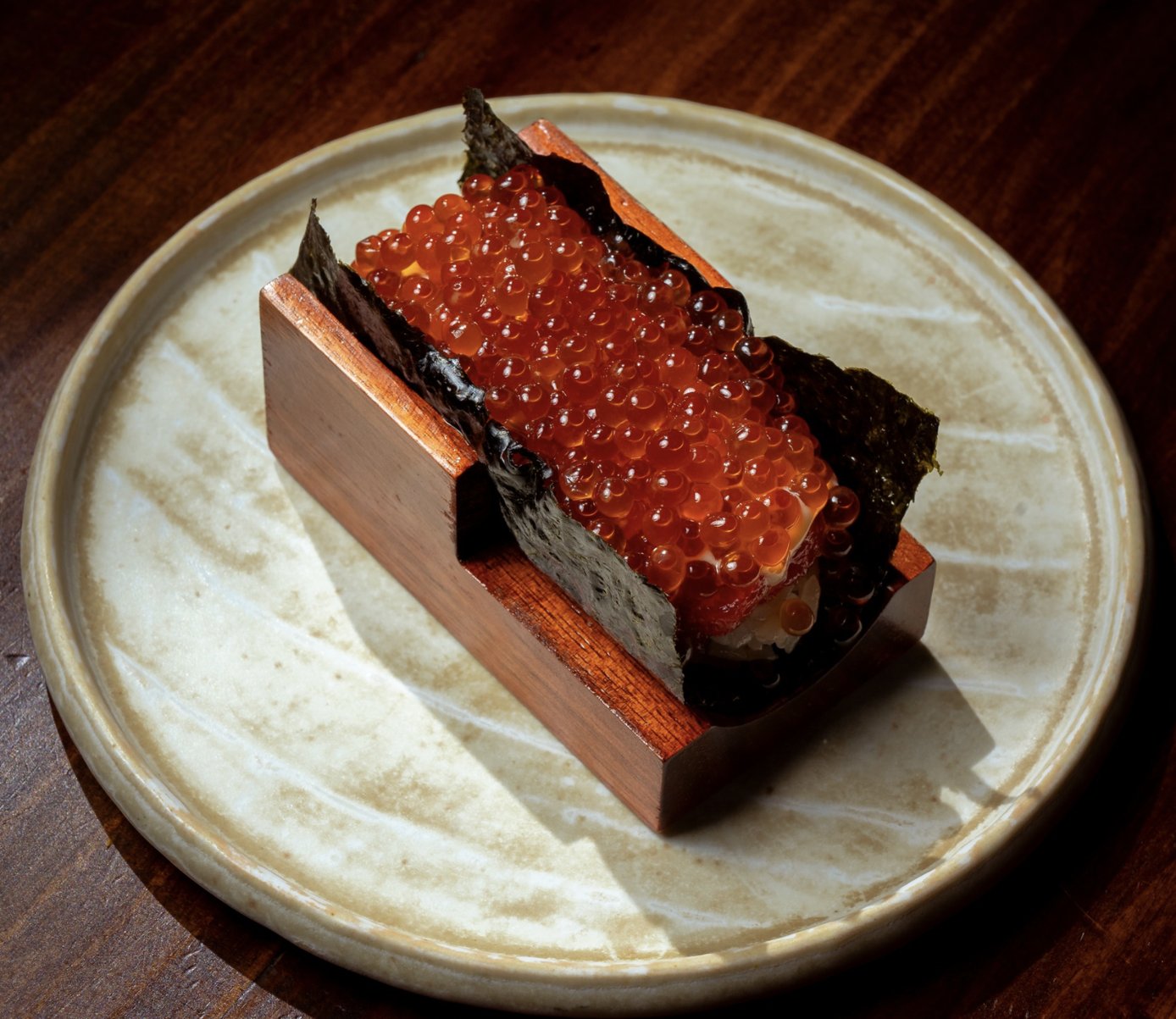 Temaki ikura cuốn tay trên giá gỗ