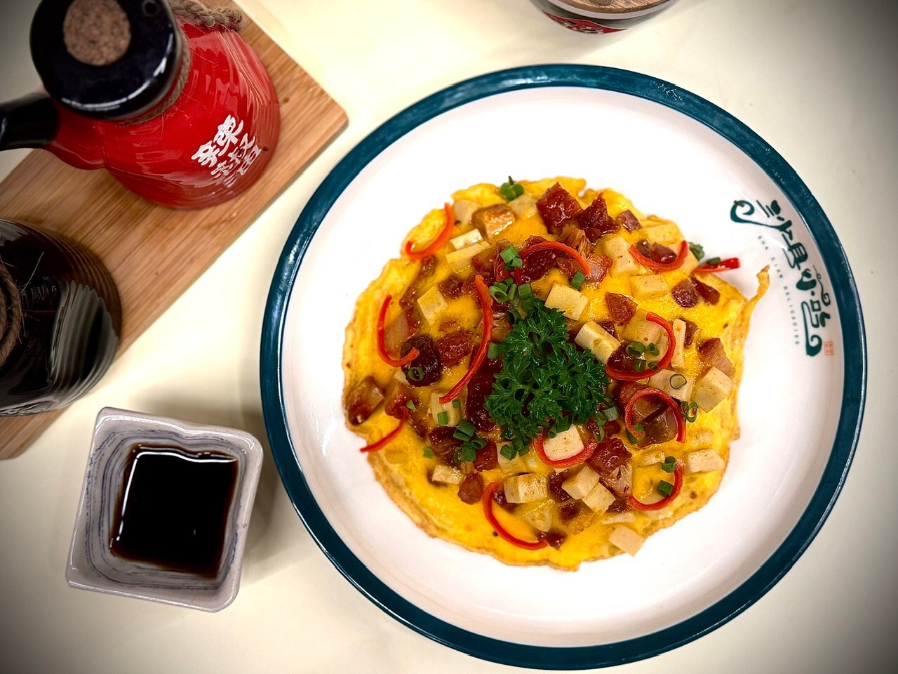 Golden folded omelet with diced char siu, chili threads and scallion